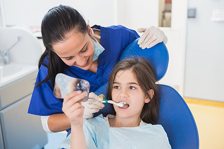 儿科牙医为她的年轻病人刷牙童年微笑设备牙科打扫孩子口腔护士磨砂膏牙齿图片