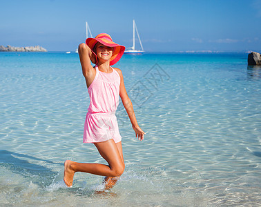 海滩上的女孩童年幸福支撑裙子娱乐旅行家庭假期太阳海岸图片