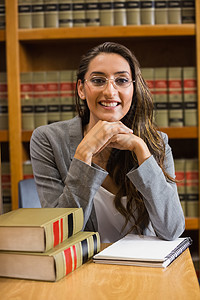 法律图书馆的漂亮律师教科书女性教育体积校园架子微笑大学高等教育快乐背景图片