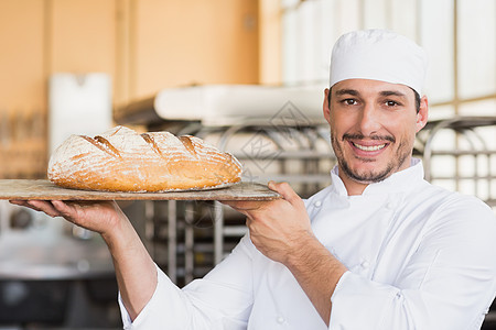 贝克拿着新鲜的烤面包厨师工作制服店铺微笑餐厅厨房酒店职业男人图片