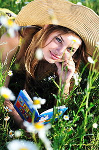 读书的少女公园太阳女性草地女学生微笑小学生学习学校雏菊图片