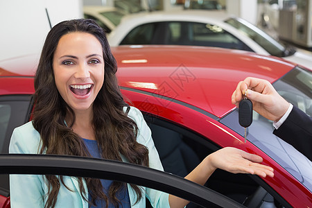 兴奋的女性收到车钥匙购物专业销售汽车陈列室职业快乐运输代理商营业员图片