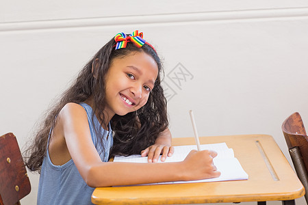 在课堂桌上写字的可爱学生小学生写作童年桌子记事本早教小学椅子笔记本学习图片