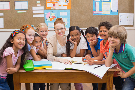 教师和学生在办公桌一起工作教育老师铅笔班级男生学习课堂小学生女性快乐图片