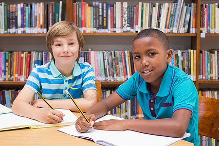 图书馆绘画的可爱学生学校同学们写作班级小学生瞳孔童年男性混血书架图片