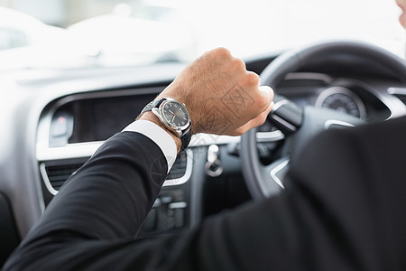 司机座椅上的商务人士窗户前座领带夹克套装车辆检查汽车腕表驾驶图片