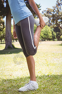 漂亮的女人在公园里伸展绿地竞技护理晴天运动服生活方式女士锻炼运动热身图片