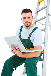 使用笔记本电脑坐在梯子上的木匠维修工艺人职业修理工男人工人工作服男性体力劳动技术员图片