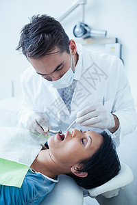男牙医检查女牙医牙齿口腔科医疗女性工具女士卫生专业混血手术病人背景图片