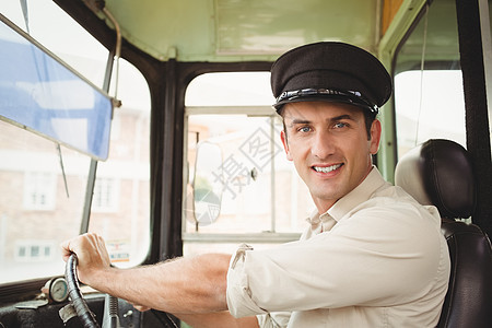 驾驶校车的微笑司机方向盘男性教练职业男人小学学校交通交通工具公共汽车图片