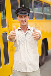 微笑的公共汽车司机看着相机帽子运输职业服务快乐教练黄色小学客车校车图片