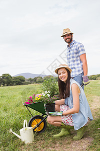 快乐的年轻夫妇一起园艺爱好花园空闲花坛花盆男人种植微笑生活女士图片