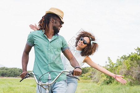 骑自行车的年轻夫妇微笑草原夫妻感情女士女性男性自由快乐潮人图片
