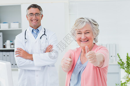 病人在与医生站在一起时显示拇指抬头的标志图片