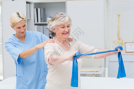 护士协助高级病人使用抗力带进行锻炼;图片