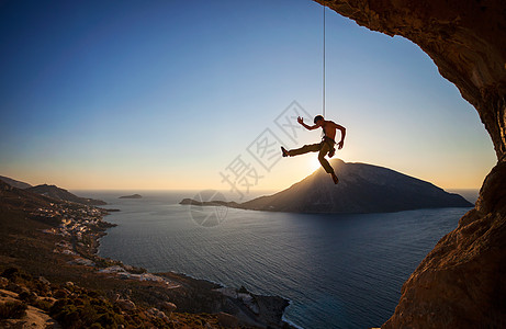户外攀岩攀岩者悬在绳索上 同时铅攀山挑战成人男性电话风险高度天空运动太阳安全背景