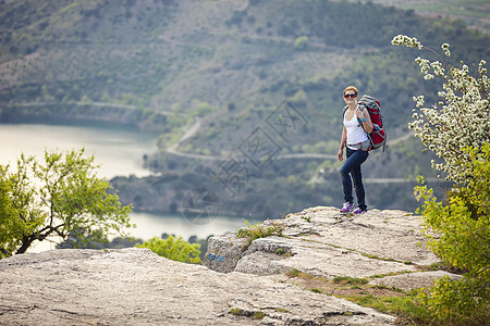 女旅行者站在悬崖上微笑图片