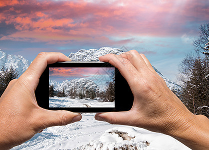 甜品图片男人和女人用手抓住阿尔卑山冬风景技术旅游白色相机屏幕摄影场景蓝色滑雪电话背景
