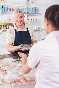 男人把白鲑鱼给花匠财产市场店铺服务男性女士顾客桌子微笑食物图片