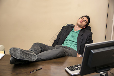 过度工作 疲劳的年轻商务人士睡在办公桌前图片