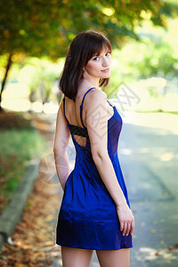 穿蓝裙子的年轻美女 在夏日公园散步图片