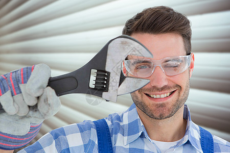 自信的修理工身戴保护眼镜 同时握着扳手的复合图像图片