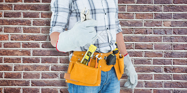 技术员的复合图象 用工具带套在腰持钳子上工作黄色工人腰部建筑师手工具建筑男性木匠职业图片