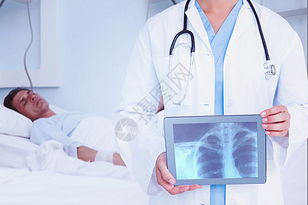 医生在平板电脑上看X光的复合图像从业者男性说谎疾病治疗诊所男人房间静脉专家图片