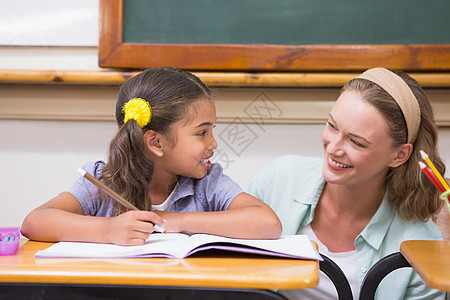 教师在课堂帮助学生教学职业小学生瞳孔童年教育老师女性女士混血图片