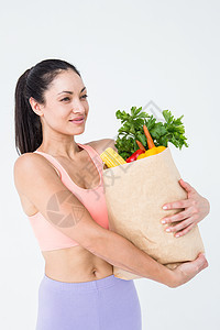 携带健康食品袋的Slim妇女女性生活方式文胸身体运动护理微笑运动服竞技调子图片