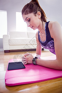 适合的女士在垫子上做木板运动服身体竞技运动垫电脑护理姿势运动微笑支撑图片