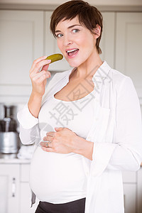 孕妇吃一罐泡菜服装女性房子微笑休闲厨房待产公寓短发快乐图片