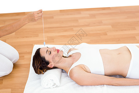 妇女躺在地上时被催眠顾问毛巾治疗生活方式中心疗法精神头发催眠师酒店背景图片