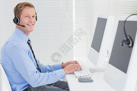 在键盘上打耳机的英俊特工客户套装服务男人人士代理人沟通公司中心商业图片