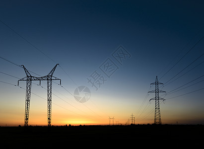 日落时大型发射塔框架力量绝缘子传播金属活力日光电气天空地平线图片