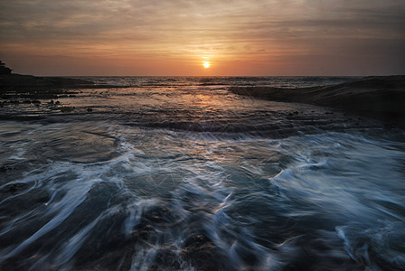 快速波浪海景日出海滩海洋地平线季节日落天空天气蓝色岩石晴天图片