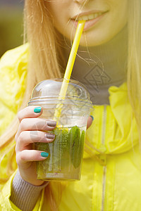 女孩喝着一大杯柠檬水塑料薄荷太阳茶点树叶饮料金发女郎嘴唇射线女性图片
