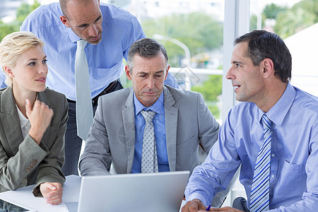 商业团队在笔记本电脑上合作合伙伙伴同事杯子商务生意人行政人员沟通领带桌子图片