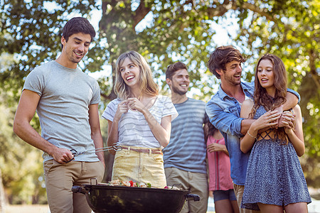 快乐的朋友们在公园吃烤烤肉烧烤朋友男性青少年闲暇草地阳光女性烹饪感情图片