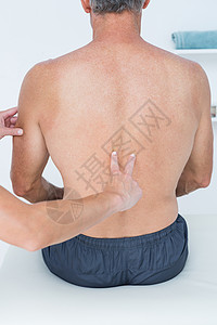 医生给她的病人做复诊检查矫正脊椎臀部织物姿势男性双手肌肉医疗医疗室图片