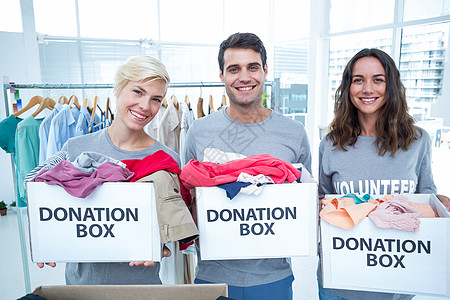持有捐赠箱的志愿者朋友志愿男性女性盒子福利微笑女士衣服社会团队图片