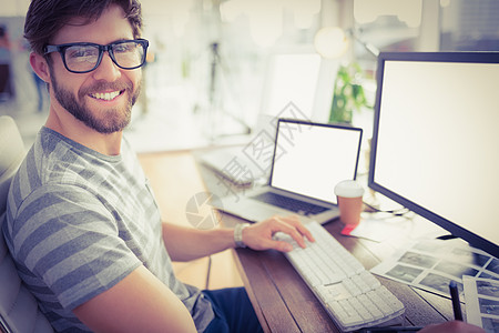在办公室使用计算机的临时性商业经营人微笑人士休闲技术电脑显示器职场男人商务职业桌子图片