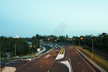 黄昏时驾驶的汽车标记道路速度沥青电灯旅行天空车道街道车辆图片