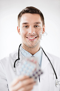 年轻男医生 带一包药丸药品剂量药物药片镇痛药男性药店长袍援助疾病图片