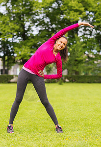 笑着的黑人女人在户外伸腿护理微笑运动手臂运动装损失爆炸幸福重量身体图片
