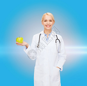 带着绿苹果 微笑着的女医生专家营养药品维生素家庭实习生蓝色保健长袍从业者图片