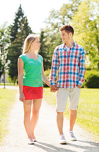 在公园中行走的一对笑着微笑的夫妇恋人幸福男朋友女士情侣女孩青少年女朋友家庭友谊图片