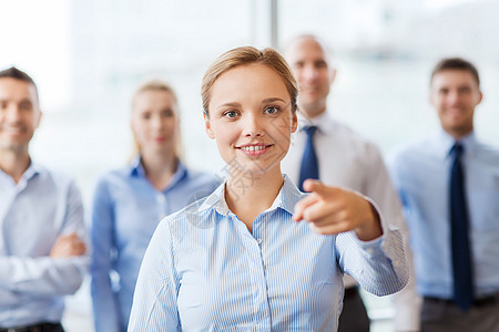 微笑着的女商务人士指着你的手指商界伙伴商业生意人团队合作女士办公室男人人员图片
