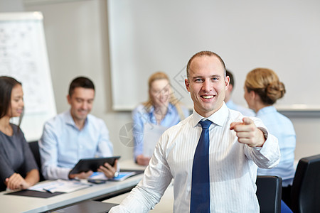 一群微笑着的商界人士在办公室开会快乐团队经理商务手势手指同事房间生意人团体图片
