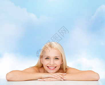 美丽的年轻女子的干净的脸和肩膀保湿微笑蓝色女士皮肤治疗化妆品幸福女孩护理图片